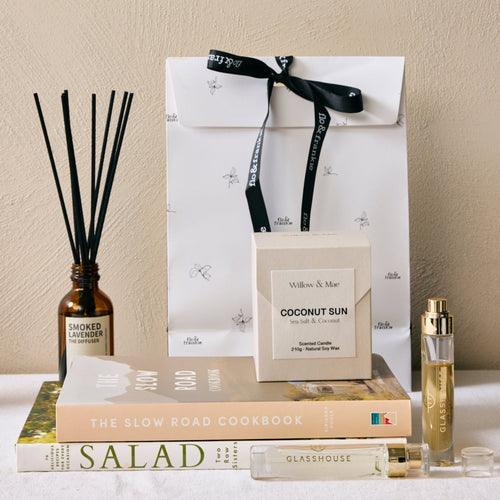 Decorative setup with a diffuser, books, and a bottle on a neutral background