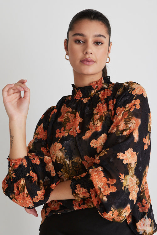 model wears a black floral top