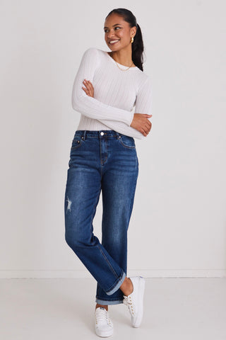 Model wears blue jeans with a white top 