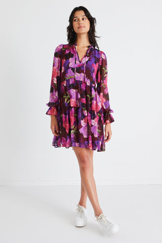 model wears a purple floral mini dress