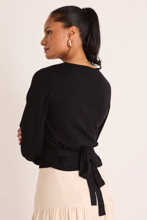 model wears a black wrap knit