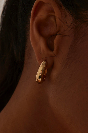 model wearing Chunky Drop Gold Hoop Earrings