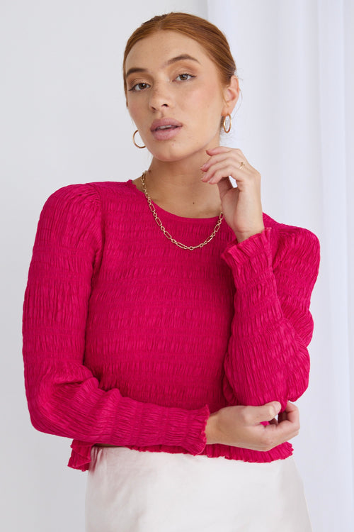 Model wears a long sleeve pink blouse