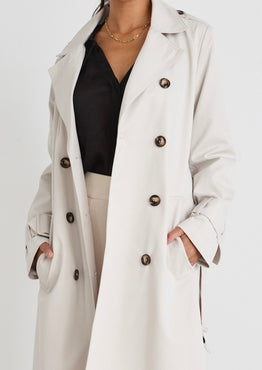 model wears a beige trench coat