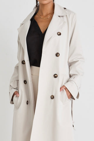 model wears a beige trench coat