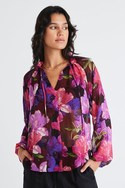 Model wears a purple floral blouse