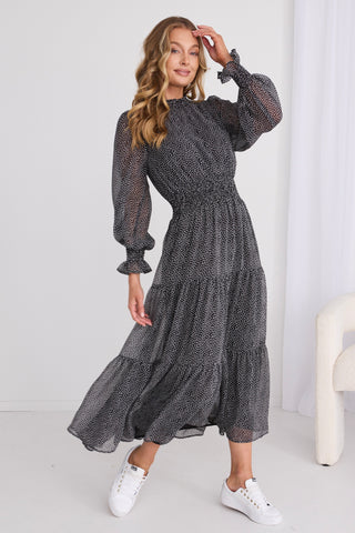 model wears a black print dress
