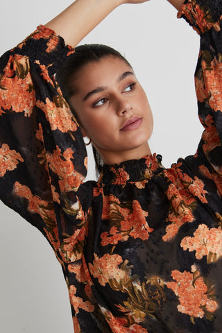 model wears a black floral top