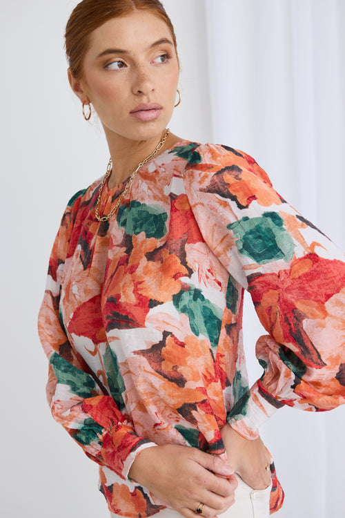 model wears a orange floral top