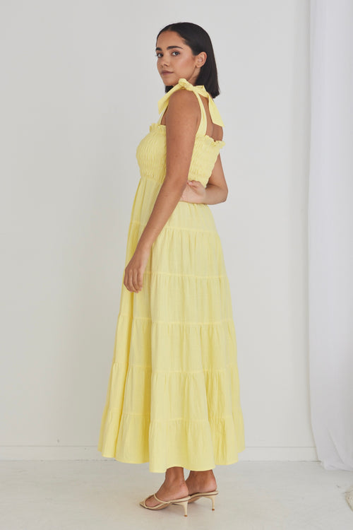 model wearing long yellow maxi dress and heels