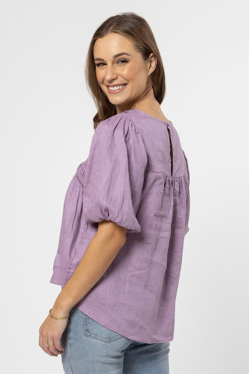 model wears a purple top with jeans