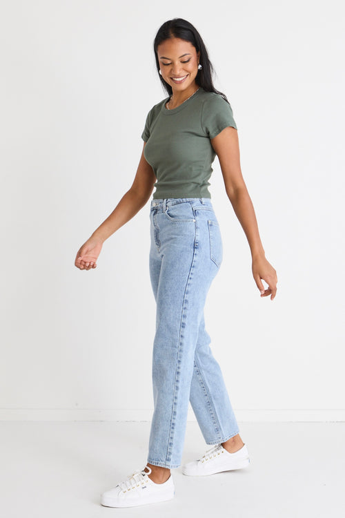 model wears blue jeans with a khaki tee