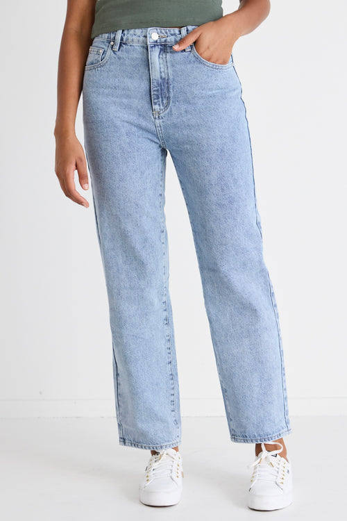 model wears blue jeans with a khaki tee