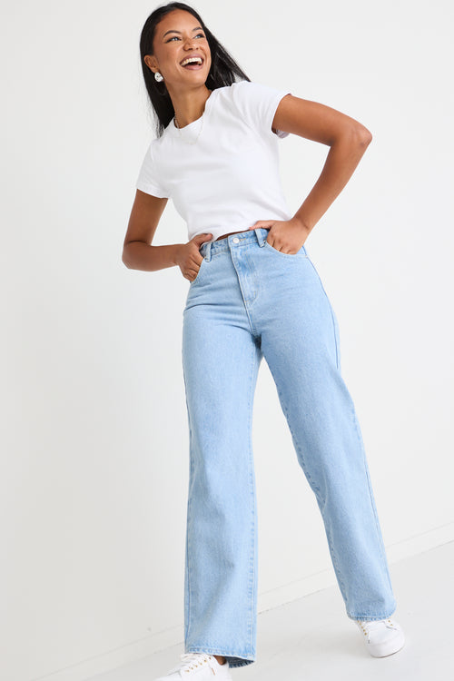 model wears light blue jeans with a white tee
