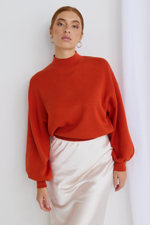 model wears a red knit