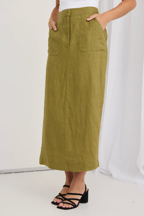 model wears a green skirt and white shirt