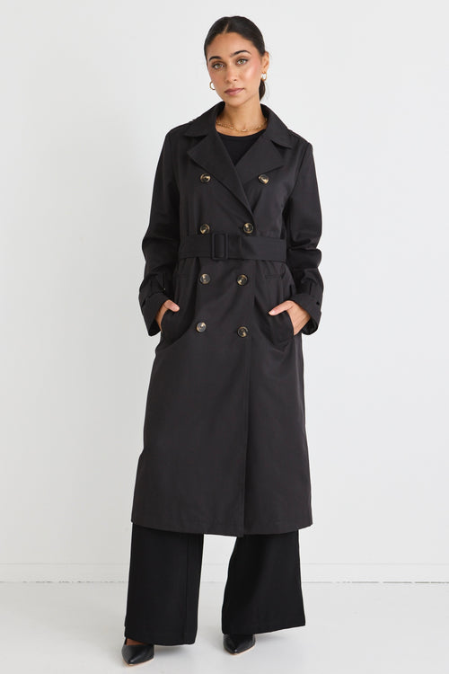 model wears a black trench coat