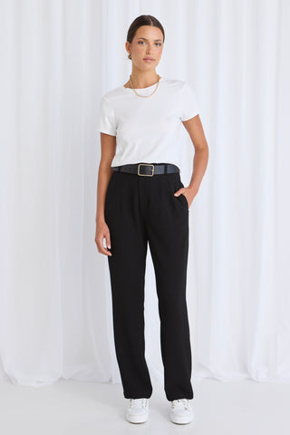 model wears black pants with a white tee