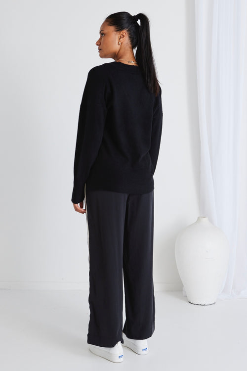 model wears a black knit