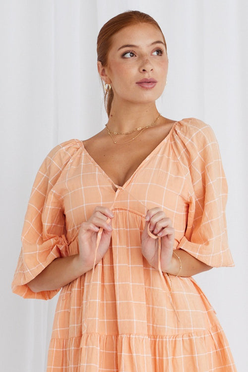 Model in orange mini dress