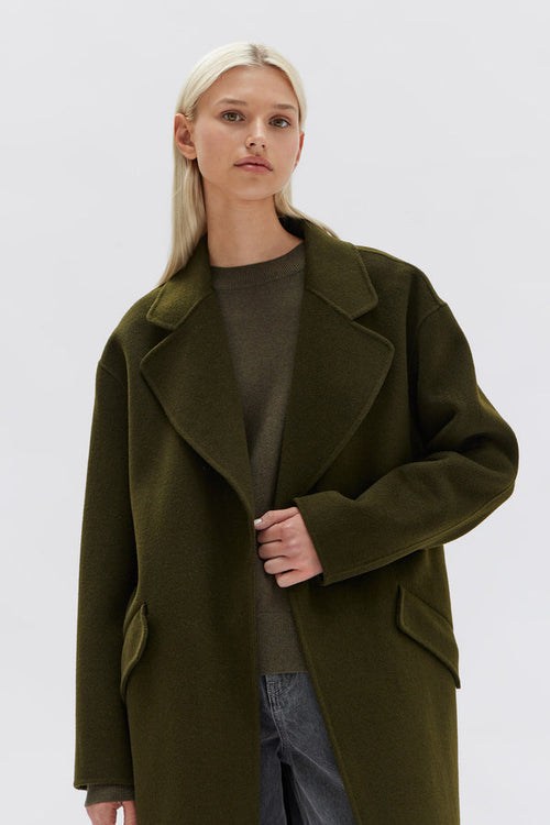 model wears a green wool coat