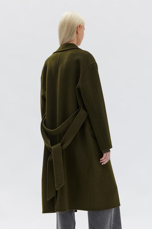 model wears a green wool coat