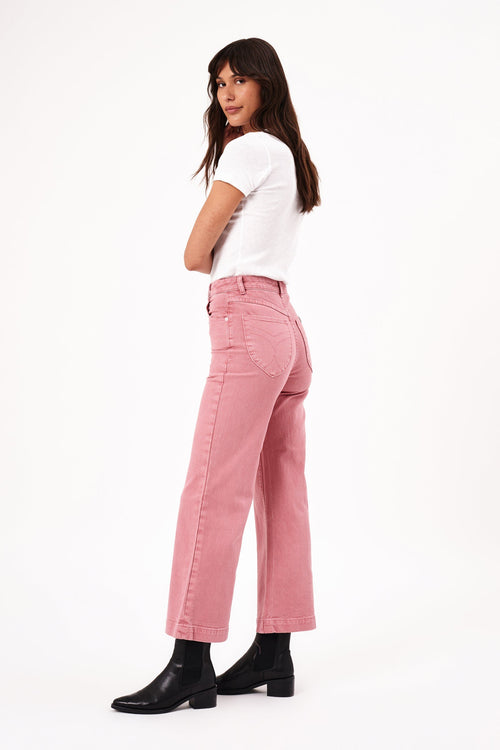 model wears pink jeans with a white tee shirt