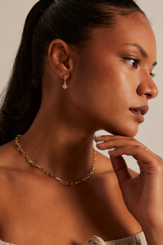 Model wears star pendant earring 