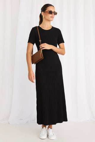 model wears a black knit midi dress