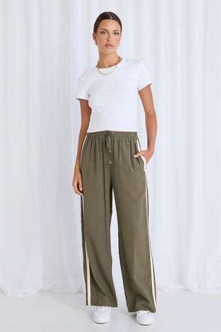 Model wears green pants with a white tee