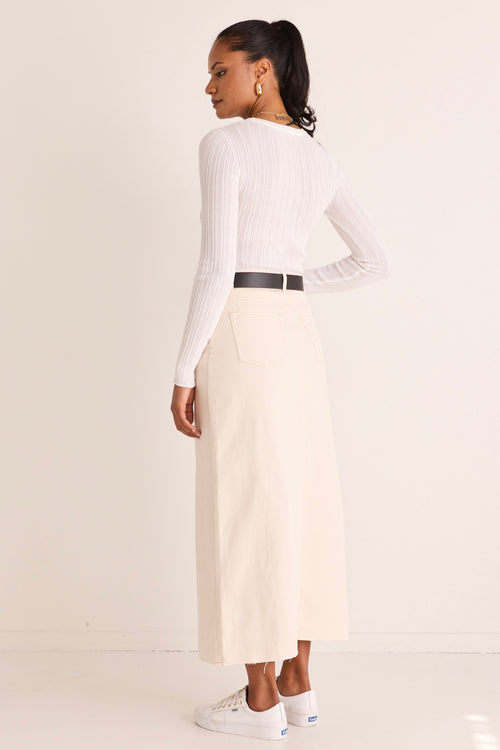 model wears a white denim skirt