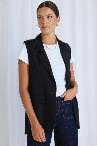 Model wears a black vest with jeans
