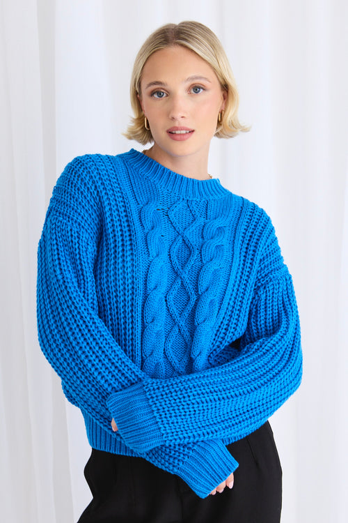 model wears a blue cable knit with black pants