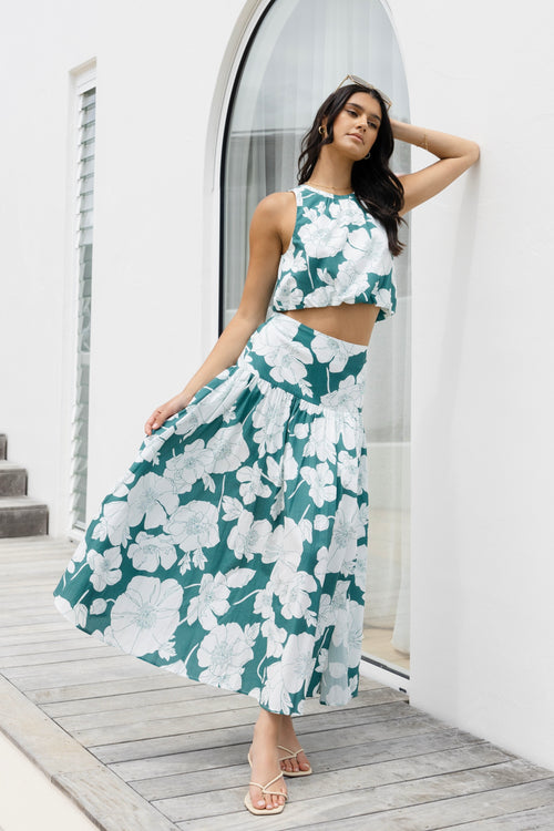 Model wears a green floral skirt and green floral top