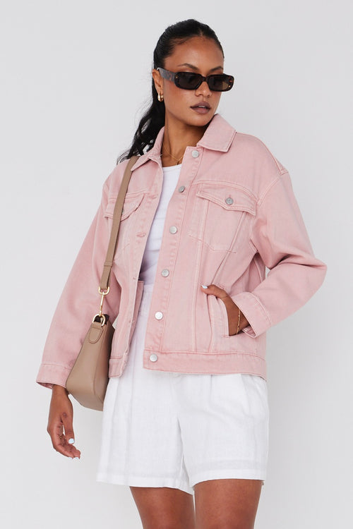 model wears a pink denim jacket and white shorts