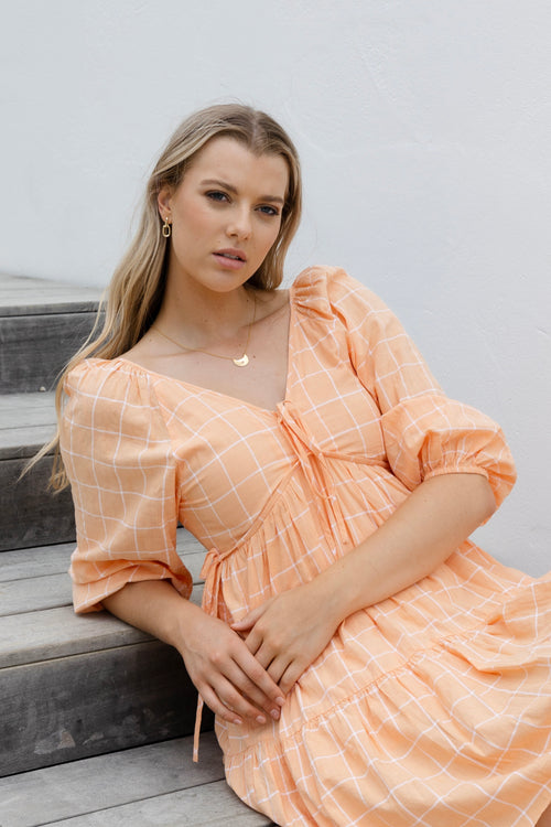 Model in orange mini dress