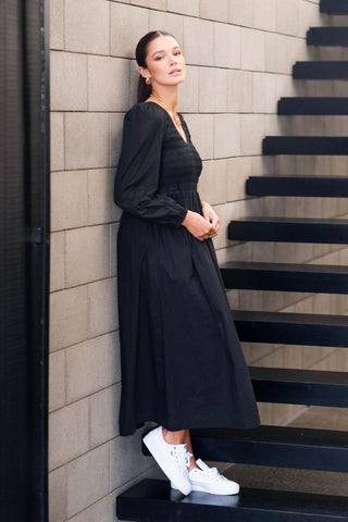 model wears a black long sleeve dress