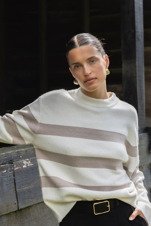 model wears a stripe knit with black pants