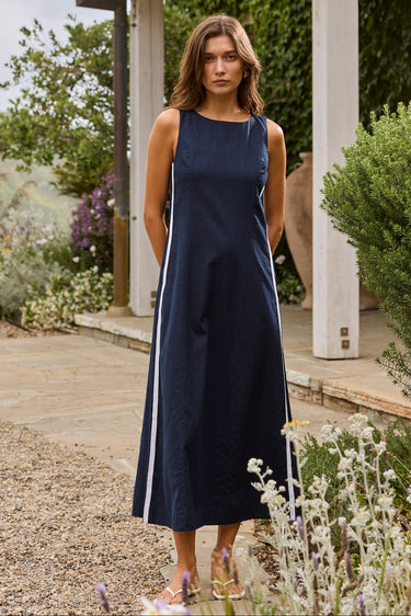 Woman in a navy dress standing in a garden setting
