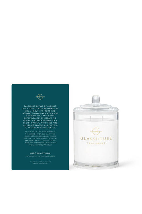 Glasshouse candle with a matching teal label on a white background