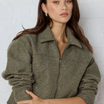 Woman wearing a green jacket against a white background