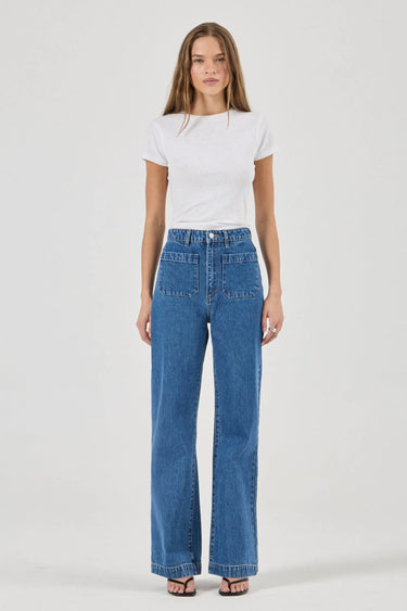 Woman wearing a white t-shirt and blue jeans on a white background