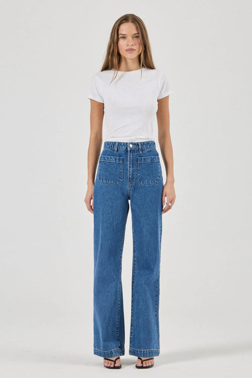 Woman wearing a white t-shirt and blue jeans on a white background