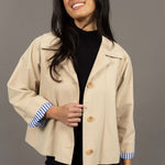 Woman wearing a beige jacket with a gray background
