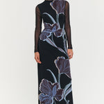 Woman wearing a black dress with floral patterns on a white background