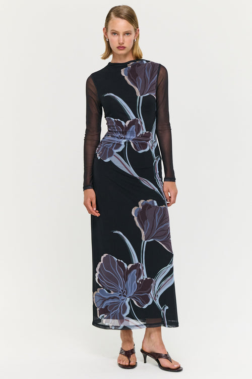 Woman wearing a black dress with floral patterns on a white background