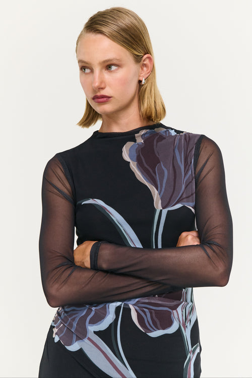Woman wearing a black dress with floral patterns on a white background