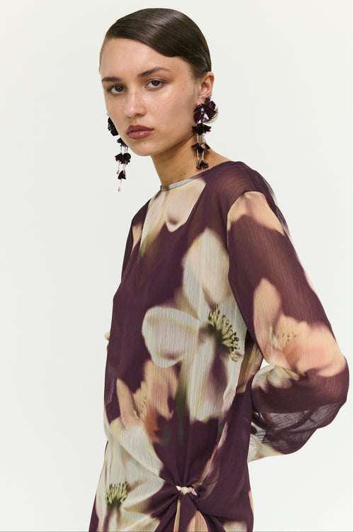 Woman wearing a floral dress with a plain background