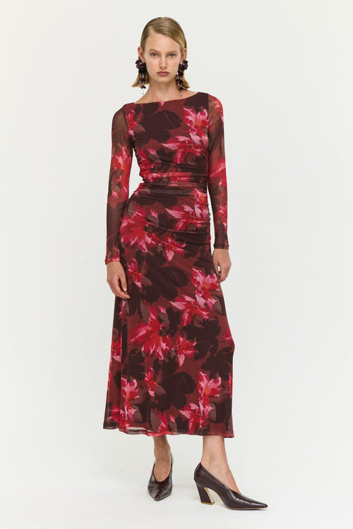 Model wearing a floral dress with long sleeves on a white background
