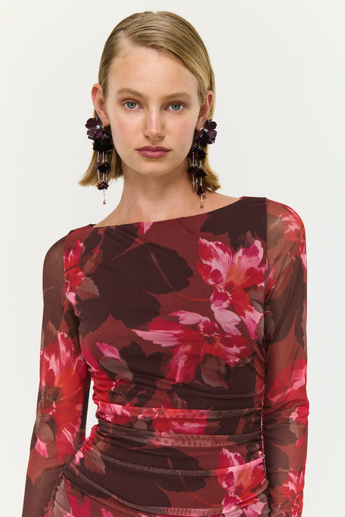 Woman wearing a red floral dress against a white background